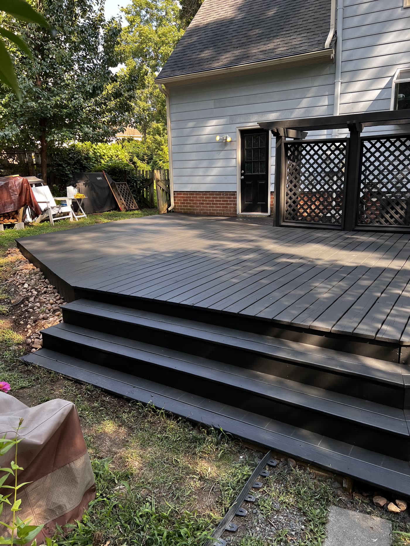 Weathered deck restored with solid charcoal stain and rebuilt cascading stairs